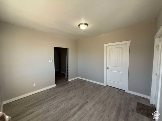 Unfurnished bedroom with wood-type flooring and a closet