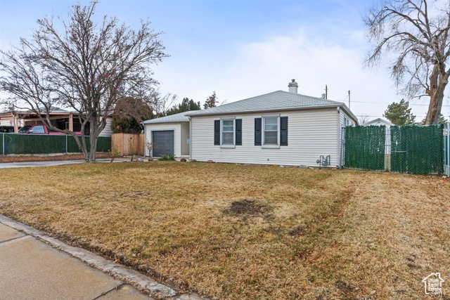 View of front facade featuring a garage and a front lawn