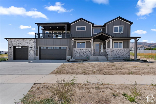 View of front of house featuring a mountain view, a garage, and a balcony