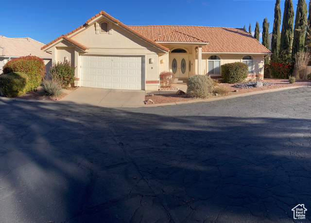 Mediterranean / spanish-style home with a garage