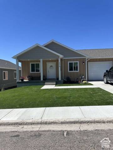 Ranch-style house featuring a front lawn and a garage