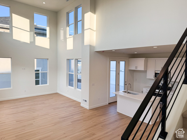 Interior space featuring hardwood / wood-style flooring, a towering ceiling, and sink