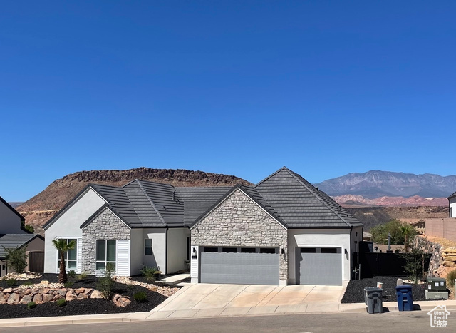 View of front of house with a mountain view and a garage