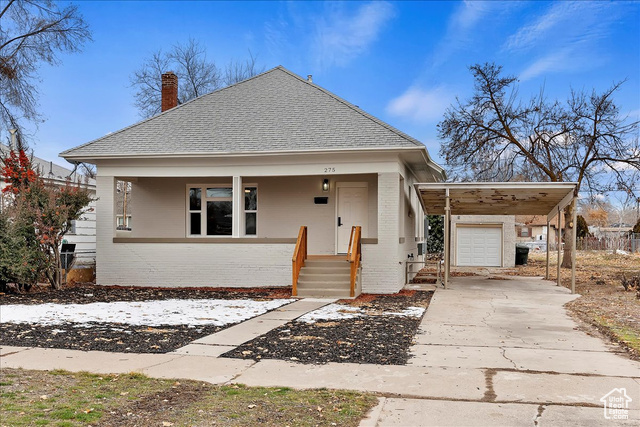 Bungalow-style house with a carport, a porch, and a garage