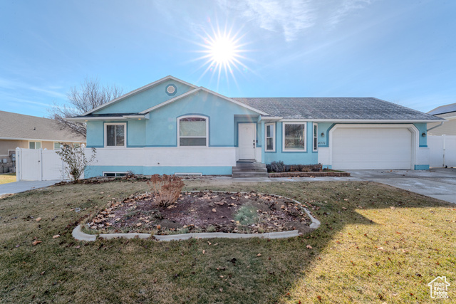 Single story home with a front lawn and a garage