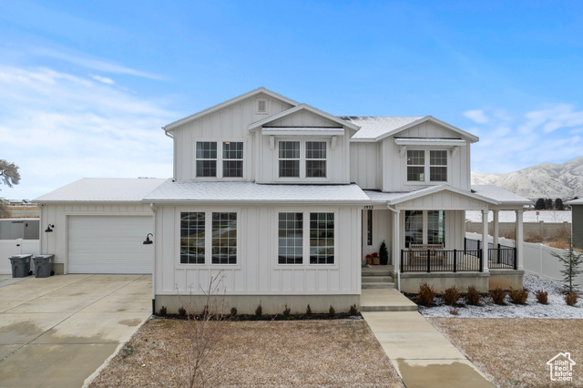 View of front of house with a mountain view, a porch, and a garage