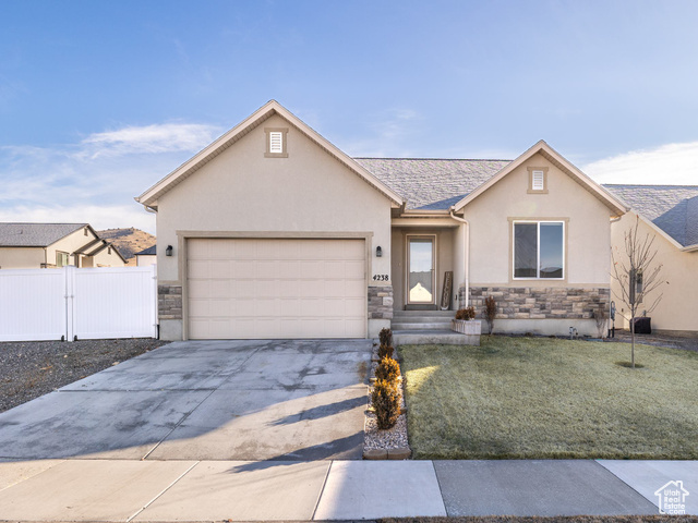 Single story home featuring a front yard and a garage