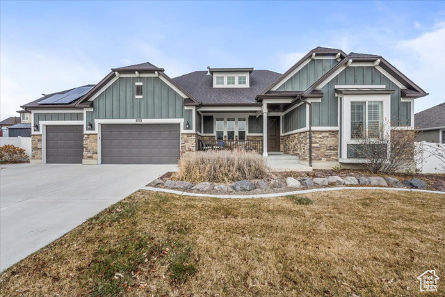 Craftsman-style house with solar panels and a front yard