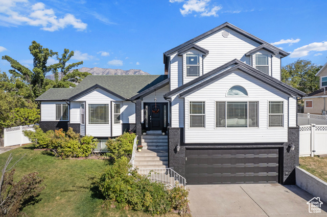 View of front facade featuring a front yard and a garage