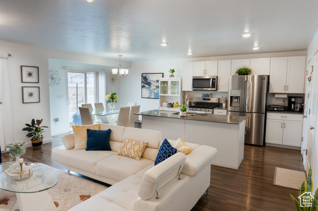 Living room featuring sink, dark hardwood / wood-style flooring, and a notable chandelier