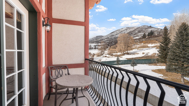 Snow covered back of property featuring a mountain view