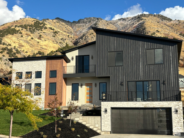 Modern home featuring a balcony, a garage, and a mountain view