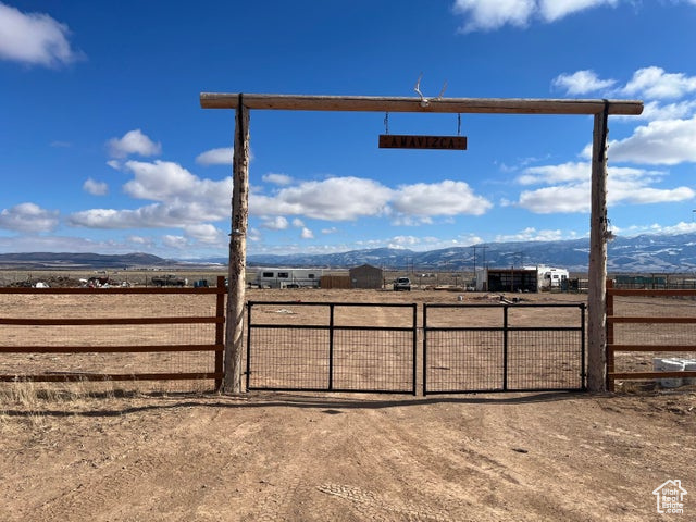 View of gate with a rural view and a mountain view