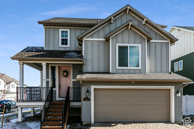 View of front of home with a garage and a porch