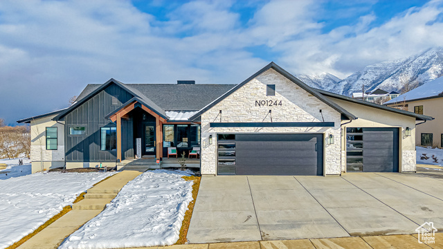 View of front facade featuring covered porch, a garage, and a mountain view