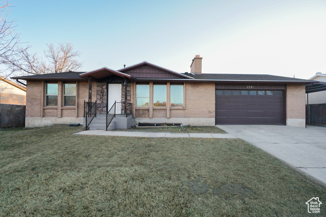 View of front of property featuring a front yard and a garage