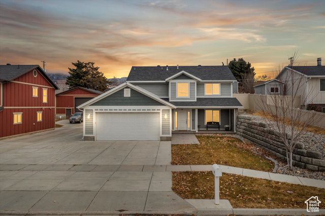 View of front of property with a porch and a garage