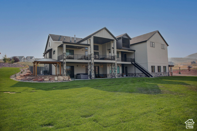 Rear view of property featuring a gazebo, a patio, central AC, and a lawn