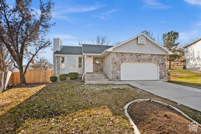 Ranch-style house featuring a front yard and a garage