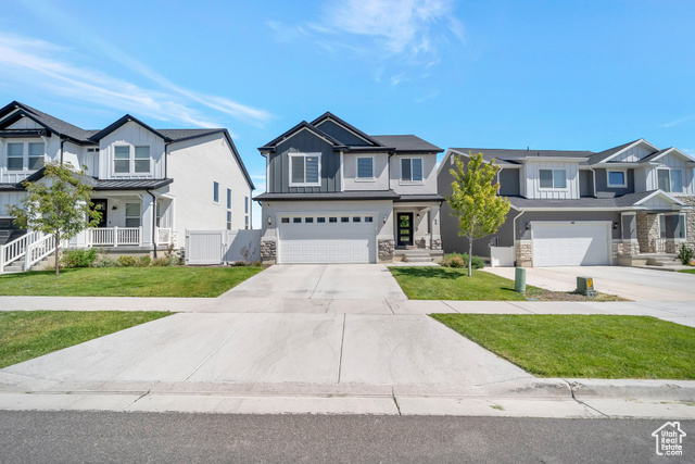 Multi unit property featuring a front yard and a garage