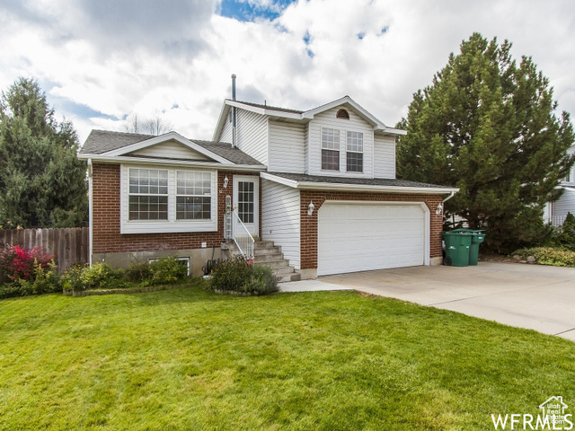 View of front of house featuring a front yard and a garage