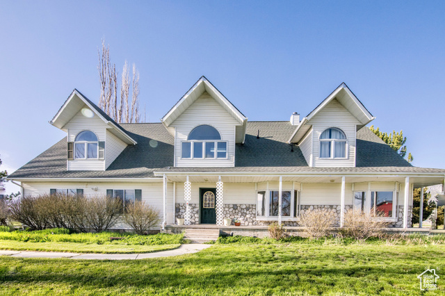 View of front of house with covered porch and a front lawn