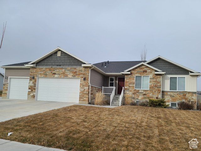 Craftsman inspired home featuring a garage, a front yard, and covered porch