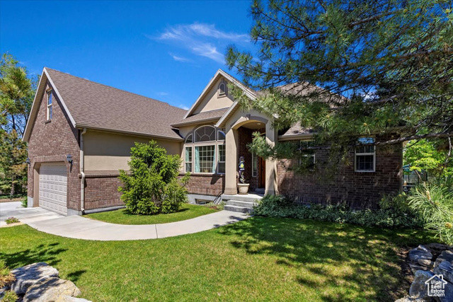 View of front facade featuring a front lawn and a garage