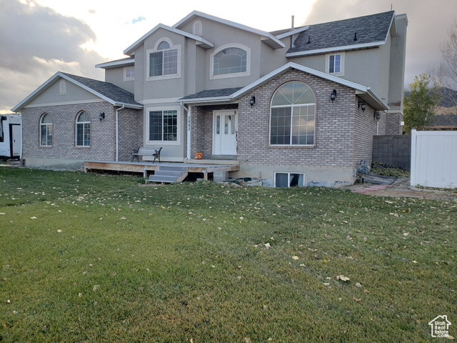 View of front of home with a front yard and a deck