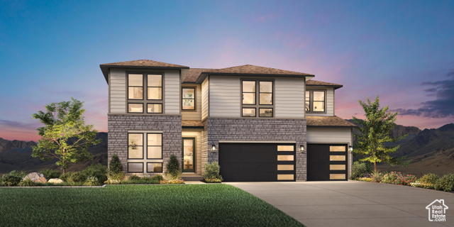 View of front facade featuring a yard and a garage