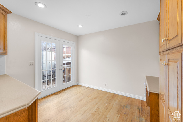 Unfurnished dining area with french doors and light hardwood / wood-style floors