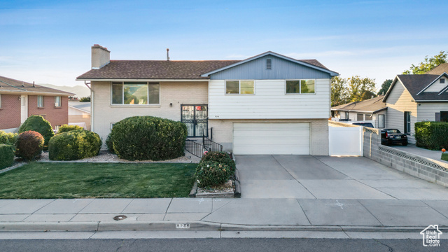 View of front of property with a front lawn and a garage