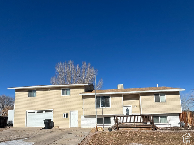 Front view of property featuring a deck and a garage