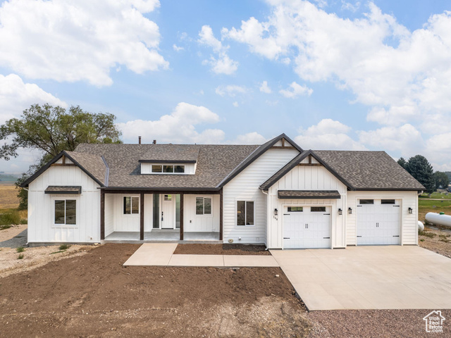 Modern inspired farmhouse with a porch and a garage