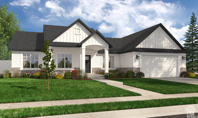 View of front facade featuring a garage and a front lawn