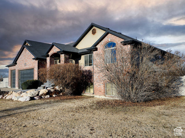 Property exterior at dusk with a lawn and a garage