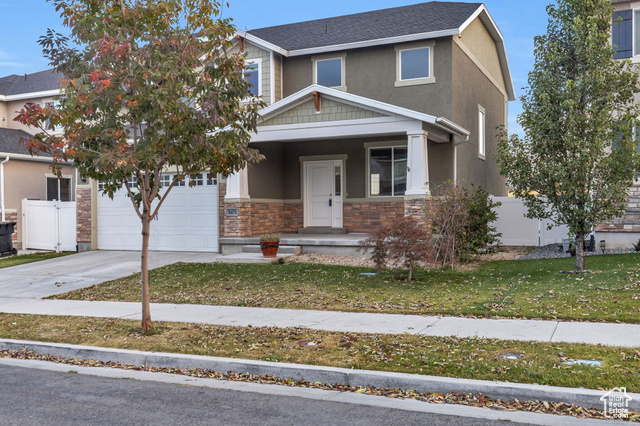 View of front of property with a garage and a front yard