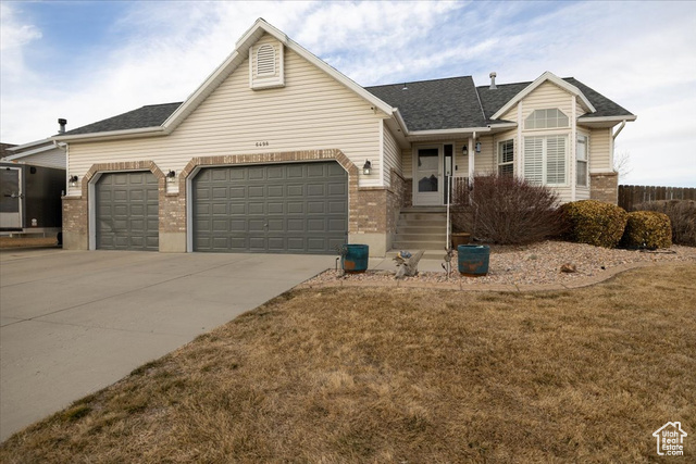 View of front of property featuring a garage and a front yard