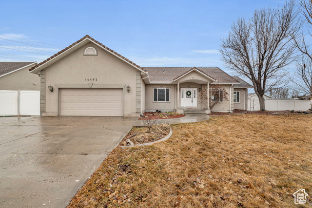 Ranch-style home with a front yard and a garage