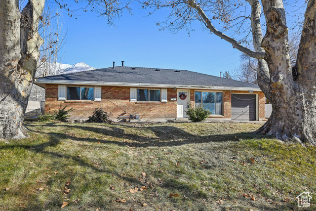 Front view of house featuring a garage and a lawn