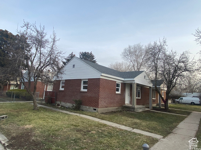 View of side of home featuring a yard