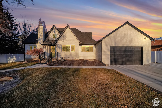 View of front of home with a garage and a lawn