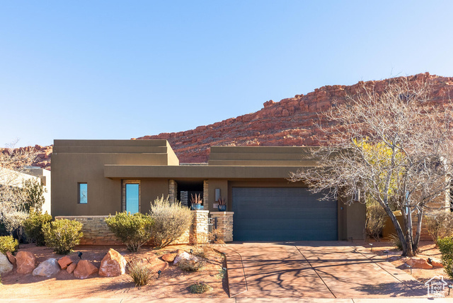 Pueblo revival-style home with a garage and a mountain view