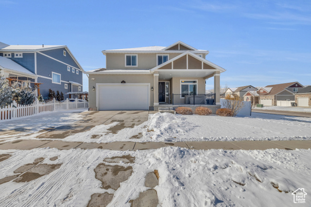 View of front of home featuring a garage and covered porch