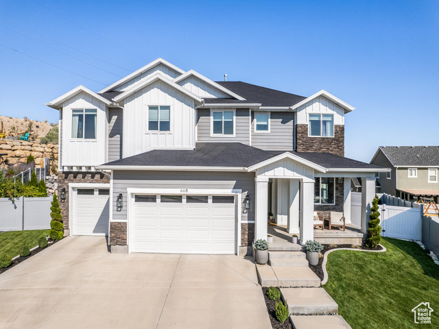 View of front of home with a garage and a front lawn