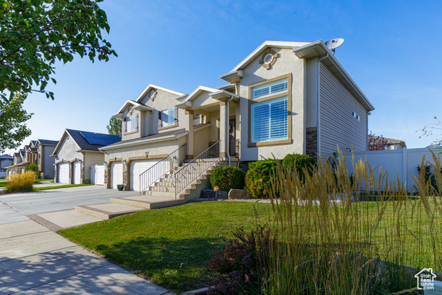 View of front of property with a garage and a front lawn