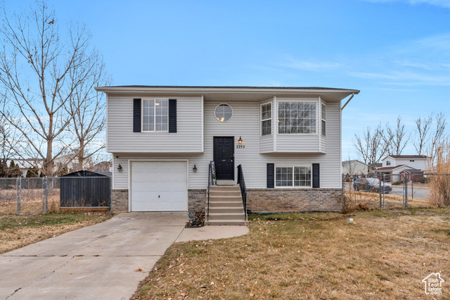 Bi-level home with a garage and a front yard