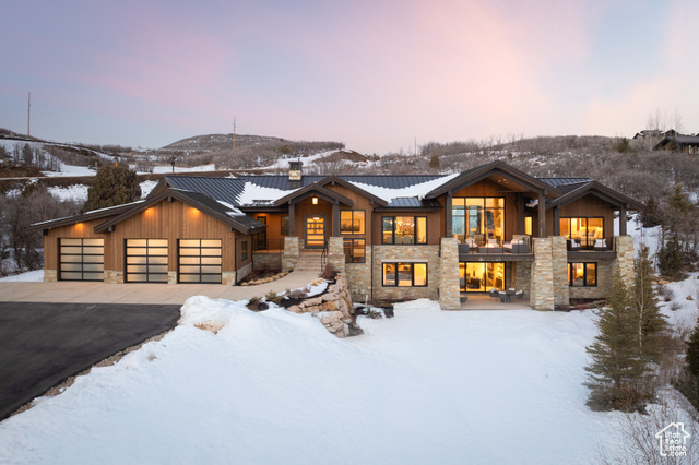 This elegant mountain contemporary newer construction home sits on a private 1.76-acre lot in Tuhaye w/full Talisker Membership. Enjoy luxury, privacy & breathtaking views of Mt. Timpanogos & Deer Valley ski runs. Ideally positioned near the signature Mark O'Meara 3rd hole & close to premier club amenities-golf clubhouse, pools, racquet courts & BaseCamp-this architectural masterpiece features interiors by Barclay Butera & craftsmanship by Summit Contractors. Designed for comfort & entertaining, the main level offers a grand foyer w/striking staircase & floor-to-ceiling windows showcasing stunning views. A chef's kitchen w/commercial-grade appliances & butler's pantry flows into the dining area & two-story great room w/soaring stone fireplace, built-ins & 2 covered terraces. The primary suite includes a spa-like bath w/heated floors, soaking tub, steam shower & expansive walk-in closet. A guest suite w/ensuite bath, oversized laundry & outfitted mudroom complete this level.  The walkout lower level features radiant heat, secondary primary suite, 2 guest bedrooms w/ensuite baths & custom bunk room. A recreation room w/distressed-wood bar opens to family room w/fireplace & terrace access. A home office & abundant natural light complete the space, w/views rivaling the main level. The Crestron system integrates AV & electronic window treatments for smart-home living.  Upgrades by current owners include custom landscaping & lighting, electronic blinds, AV equipment & backup generator.  Exceptional outdoor living spaces include a front terrace w/fire pit & sweeping mountain views, a rear patio off kitchen ideal for dining & grilling, & a private primary suite terrace. Multiple lower level walkouts provide seamless outdoor access.  An oversized heated garage accommodates up to 5 vehicles & outdoor gear, featuring epoxied floors & heated concrete pad for year-round ease. Sold fully furnished, including outdoor furnishings, making it a turnkey alpine retreat.