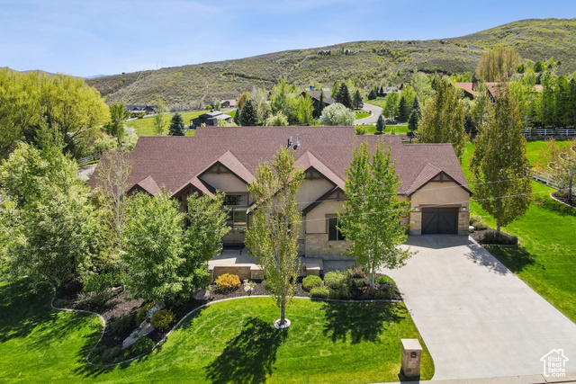 Discover refined mountain living in this stunning custom-built home nestled in the heart of charming Midway. Set on an expansive and rare 1-acre double lot, this 4,400 sq. ft. masterpiece offers 5 spacious bedrooms and 4.5 appointed baths, combining refinement, comfort, and functionality in every detail. Step inside to find bright, open-concept living spaces adorned with high-end finishes, soaring ceilings, and abundant natural light. The thoughtfully designed layout includes a dedicated home office with custom built-ins-perfect for remote work or creative pursuits. The lower-level walkout is an entertainer's dream, featuring a cozy fireplace, a stylish wet bar, and a secondary living area flooded with light-ideal for hosting guests or relaxing with family. Step outside to enjoy breathtaking mountain views from two expansive composite decks, including a covered area for year-round enjoyment. The professionally landscaped backyard and lower-level patio create a peaceful, private setting for outdoor dining, gatherings, or simply soaking in the serene surroundings. The oversized 3-car garage provides ample space for vehicles, toys, and gear-essential for taking advantage of Midway's incredible outdoor lifestyle. You'll be just minutes from five golf courses, Wasatch Mountain State Park, blue-ribbon fishing on the Provo River, scenic hiking and biking trails, and only 15 minutes from the new Deer Valley East Village Resort. Meticulously maintained and gently used as a vacation home, this property also features brand-new carpeting throughout. The double lot, each half an acre with separate tax IDs, offers flexible options-build a second home, guest house, possible horse property, or sell the extra parcel. This is more than a home-it's a lifestyle. Don't miss this rare opportunity to own a luxurious retreat in one of Utah's most sought-after mountain communities.