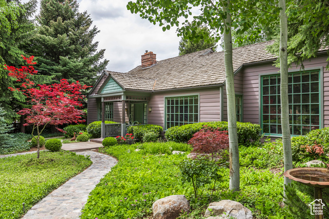 2645 E KENTUCKY AVE Holladay, Utah Nestled in one of Holladay's most beautiful half-acre lots, this charming property feels like coming home. Owned by a celebrated designer, the yard is a thoughtfully curated retreat with outdoor seating areas, stone walkways, a pergola, mature trees, charming gates, flowering ground cover, and peaceful resting spaces. Nature is the heart of this property. The home seems to be designed for the same purpose - with large windows bringing the outdoors inside. The great room in particular has a massive window granting private views of the wooded landscape. You will enjoy the same views from the living & dining rooms, as well as an attractive mudroom with a washroom (which could easily be made into an upstairs laundry). The main floor features 3 bedrooms (2 with ensuite bathrooms) and a family bathroom with a stained glass skylight. Downstairs you will find a 4th bedroom and a versatile den or rec room. The exterior of the home boasts timeless architectural details, including a wood shake roof, redwood siding, lovely millwork, and classic lines that will never go out of style. Though the setting feels secluded, it's conveniently located just steps from Holladay Village's boutiques, restaurants, food park, library, and City Hall Park. You will enjoy the benefits of living in a walkable community with the ease of a freeway entrance only minutes away, offering quick access to skiing, hiking, downtown SLC, and the airport. Homes like this don't come around very often. With its ideal location, charming outdoor spaces, and classic cottage design, this is one you won't want to miss.